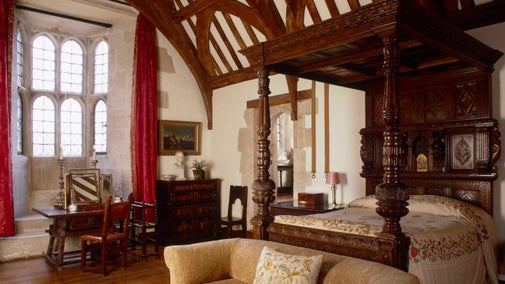 The North Bedroom at Chalfield Manor with four-poster wooden bed and beamed ceiling